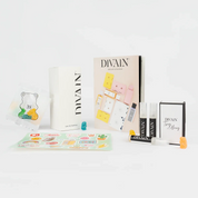 Paquet divain ouvert contenant le parfum divain-953, autocollants et bonbons
